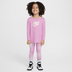 This 2-piece set was designed for easy going days home on the couch just as much as it is for fun times at the park. The tee is made of soft drapey jersey with a slightly flared cut that allows for freedom of movement. The tagless crewneck provides easy wear and the long sleeves add cozy, lightweight warmth. The matching leggings have a comfy stretch waistband and are made of stretch poly enhanced with quick-drying, moisture-wicking Dri-FIT technology to help keep your child cool and dry as they Nike Casual Loungewear Sets, Nike Long Sleeve Loungewear Sets, Nike Loungewear Sets, Nike Pink Activewear For Loungewear, Playful Pink Activewear For Spring, Playful Nike Tops For Playtime, Nike Playful Tops, Matching Leggings, Leggings Set