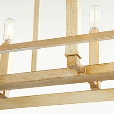 two light bulbs are hanging from a wooden frame with wood slats on the sides