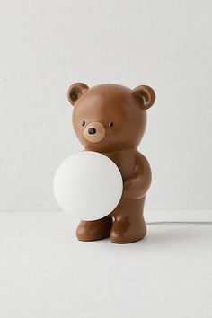 a small brown bear holding a white ball