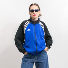 Vintage 90's Adidas track jacket with a front zip - in blue-black with white stripes - embroidered logo on the chest and on the back - 2 outer pockets with zipper closure - materials: polyester SIZE from the tag: USA M, D 6, GB 40/42", F 180 Best fits women: L MEASUREMENTS width from armpit to armpit: 24 inches (61 cm) length: 27 inches (68 cm) sleeve length from the neck: 29 inches (74 cm) The model is 5'9" (174 cm), measures 35-27-38 (89-69-96 cm) and typically wears clothing in size M CONDITI Sporty Blue Windbreaker With Zipper Closure, Blue Sports Track Jacket With Zipper Closure, Sportswear Outerwear With Contrast Stripes For Streetwear, Three Stripes Track Jacket For Sports Events, Sporty Adidas Track Jacket For Sports Events, Contrast Stripes Outerwear For Streetwear, Adidas Logo Winter Track Jacket For Sports Events, Adidas Winter Sports Track Jacket, Blue Sporty Track Jacket With Zipper