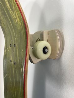 a skateboard mounted to the side of a wall with a white ball on it