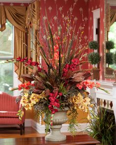 a large vase filled with flowers on top of a table next to a fire place