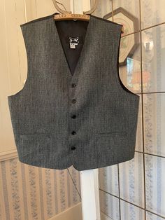 This vest from R2 is made from a blend of 82 per cent polyester and 18 per cent rayon in a black and light grey mix. It has the original buttons and two front pockets. The back and lining are made from silky black fabric. Marked size medium. The measurements, taken with the vest lying flat, are: shoulder to shoulder, 16 inches; armpit to armpit, 22 inches; length, 24 1/2 inches in front and 22 inches in back; bottom edge, 24 inches. In very good condition. Fitted Waistcoat, Grey Waistcoat, Tailored Vest, Grey Vest, Vest Outfits, Black Fabric, Vintage Black, Light Grey, Gender Neutral