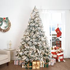 a white christmas tree with presents under it