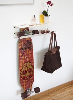 a skateboard hanging on the wall next to a purse