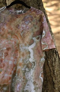 a tie dye shirt hanging on a tree