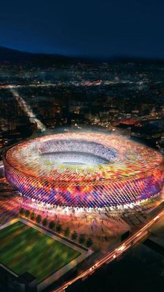 an aerial view of the olympic stadium in london at night, lit up with colorful lights