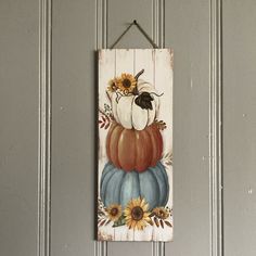 a wooden sign with sunflowers and pumpkins painted on it