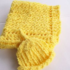 a crocheted yellow tie laying on top of a white table