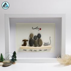 a white frame with some rocks in it and two small animals sitting on the ledge