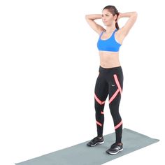 a woman standing on a yoga mat with her hands behind her head