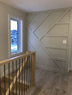 an empty room with wooden stairs and sliding glass doors on the wall, looking outside