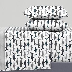 two sheets with black and white designs are stacked on top of each other in front of a gray background