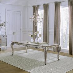 a living room with white walls and wooden flooring, chandelier hanging from the ceiling