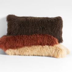 two brown and one tan pillows on a white background with the same color fur pattern