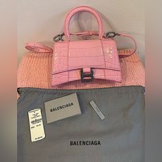 Real *Authentic* Nwt - Proof Of Purchase - Receipt Attached In Gallery. Unused. Hourglass Xs Handbag In Pink Shiny Crocodile Embossed Calfskin, Aged-Silver Hardware. Product Details Dimensions: L7,4 X H5,1 X W3,1 Inch Shiny Crocodile Embossed Calfskin Handbag Curvilinear Base One Handle Adjustable And Removable Crossbody Strap (21,6 Inch) Studded Magnet Closure Aged-Silver B Logo Hardware 1 Back Pocket Nappa Lambskin Lining Made In Italy Material: 100% Calfskin Product Sustainability Details: In Balenciaga Mini City Bag, Balenciaga Classic City Bag, Balenciaga Mini City, Balenciaga Hourglass Bag, Balenciaga Purse, Balenciaga Classic City, Felt Tote, Purchase Receipt, Balenciaga Leather