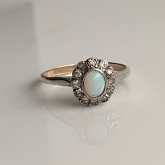 A vintage 9 carat gold paste and opal cluster ring.  CONDITION: Wear consistent with age and use. Please see photos for more detail. SETTING: 10mm x 8mm SETTING HEIGHT: 5mm BAND WIDTH: 2mm OPAL SIZE: 6mm x 4mm PASTE SIZE: 1.5mm RING SIZE: UK: N| US: 6 1/2 WEIGHT: 1.9 grams () White Stone Ring, Purple Stones, Multi Stone Ring, Multi Stone, Antique Rings, Cluster Ring, Pearl Ring, Stone Rings, Antique Gold