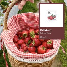 a basket filled with strawberries sitting on top of a table next to a card