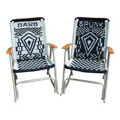 two chairs made out of woven material with wooden arms and legs, one is black and the other is white