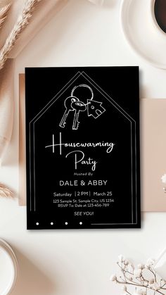 a black and white wedding party card with a key on the front, surrounded by other items