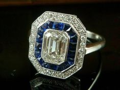 Specification:- *Diamond Material : Cubic Zirconia *Center Diamond Shape : Emerald Cut *Center Diamond Dimension : 8*6 MM  *Center Diamond Weight : 1.74 CT *Side Diamond Dimension : 1.60, 2.5*1 MM *Diamond Color : White, Blue *Diamond Clarity : VVS *Making Process: Handmade by our Experienced Staff. *Stamp: Our All Rings Stamped According to metal Purity (925 SIL/10K/14K/18K) Customization:- *Buyer can Request change of rhodium color in 925 Silver Jewelry (No additional Charge). *In Gold (10K, 1 White Diamond Gemstone Ring In Art Deco Style, White Sapphire Ring With Center Stone For Wedding, White Art Deco Baguette Cut Jewelry, Art Deco Baguette-cut Sapphire Wedding Ring, Art Deco White Sapphire Ring With Prong Setting, Art Deco Baguette Cut Sapphire Wedding Ring, White Sapphire Art Deco Jewelry, White Sapphire Ring With Halo Setting For Wedding, Wedding Art Deco Baguette Cut Sapphire Ring