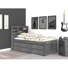 a bed with drawers underneath it and pictures on the wall above it, next to a guitar