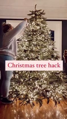 a woman standing next to a christmas tree with the words christmas tree hack written on it