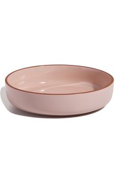 a pink bowl sitting on top of a white table