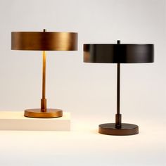 two lamps sitting next to each other on a white surface