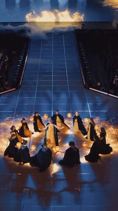 a group of people sitting on top of a floor in front of a sky filled with clouds