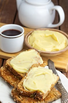 two pieces of bread with butter on them and a cup of coffee in the background