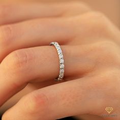 a woman's hand with a diamond ring on her left hand, showing the side view