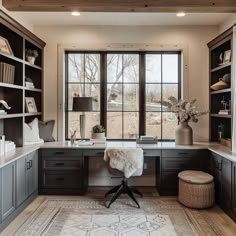 a home office with large windows and lots of shelves on the wall, along with a chair