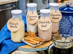 some cinnamons are sitting on a table next to jars with labels that say french vanilla