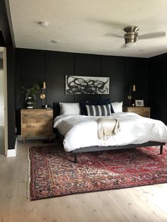 a large bed sitting on top of a wooden floor next to a dresser and lamp