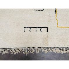 a white rug with black and yellow designs on it