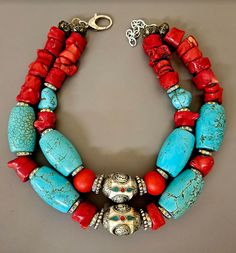 Big, bold, chunky and heavy all aptly describe this one-of-a-kind oversized beaded tribal - ethnic statement necklace. Featuring two inlaid Tibetan resin focal beads, this is primarily comprised of turquoise blue magnesite barrel beads, red branch coral nuggets, silver aurora borealis rhinestone rondelles and silver tone metal daisy spacers. The very back is finished with ornate copper beads. Adjusts from 18-20" but fits more like 17-19" given the size of the beads. Closes with silver tone hardw Bold Necklace, Focal Beads, Red Necklace, Coral Necklace, Focal Bead, Turquoise Color, Red Coral, Leather Chain, Aurora Borealis