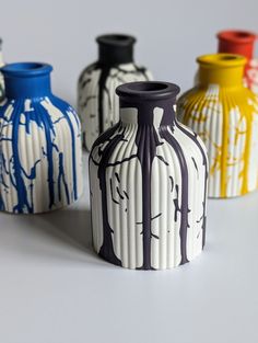 four different colored vases sitting next to each other