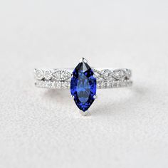 1 CT Marquise Cut Blue Sapphire Solitaire Ring Set, Lab Sapphire Engagement Ring Set, Half Eternity Milgrain Wedding Band, White Gold Bridal Ring Set, Gift For Women, Anniversary Ring For Her, Lab Blue Sapphire Gemstone Ring, Anniversary Gifts, Proposal Ring, Bridal Jewelry For Her, Half Eternity Round Cut Simulated Diamond Ring, September Birthstone Ring ● 𝐂𝐞𝐧𝐭𝐞𝐫 𝐒𝐭𝐨𝐧𝐞 𝐃𝐞𝐭𝐚𝐢𝐥𝐬: → Gemstone: Lab Blue Sapphire → Stone Type: Lab Created → Shape: Marquise Cut → Size: 1.00 CT → Meas Oval Tanzanite Diamond Wedding Ring, Oval Tanzanite Wedding Ring, Classic Tanzanite Birthstone Ring For Wedding, Blue Marquise Diamond Ring With Center Stone, Blue Marquise Diamond Ring With Diamond Cut, Blue Marquise Cubic Zirconia Diamond Ring, Classic Blue Marquise Diamond Ring, Blue Marquise Diamond Ring For Anniversary, Round Tanzanite Diamond Wedding Ring