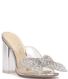 From Jessica Simpson&#x2C; the Saidah2 Pearl and Rhinestone Bow Clear Dress Sandals feature:Clear synthetic upperFaux pearl embellished oversized bowSquare toe constructionSlip on designSynthetic liningRubber outsoleApprox. 4.1" heel heightImported. Glamorous Clear Sandals With Rhinestones, Elegant Crystal Sandals For Spring, Glamorous Clear Sandals For Wedding, Clear Sandals For Summer Cocktail Events, Crystal Sandals For Formal Summer Events, Summer Formal Crystal Sandals, Chic Clear Sandals For Wedding, Glamorous Clear Sandals For Spring, Formal Clear Synthetic Sandals