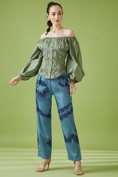 a woman in green shirt and blue pants