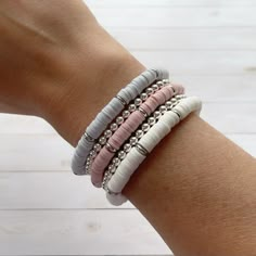 a woman's arm with three different bracelets on top of each other,