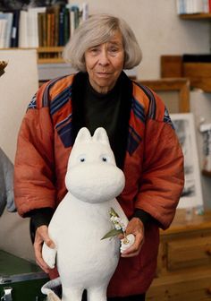 an older woman holding a stuffed animal in her hands