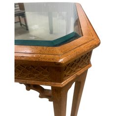 an antique wooden table with glass top