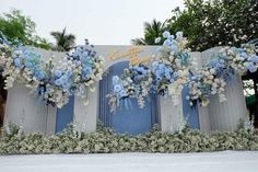 a blue and white wedding backdrop with flowers