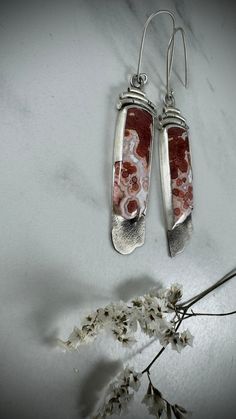 Abrace la impresionante belleza de la naturaleza con estos aretes de jaspe orbicular con borde druzy hechos a mano. Con un diseño asimétrico único, cada par exhibe los patrones y texturas naturales del jaspe orbicular, lo que garantiza un aspecto único. El acabado mate agrega una elegancia sutil, mientras que los versátiles alambres para orejas de 18 g hacen que estos aretes sean perfectos tanto para orejas perforadas normales como para orejas dilatadas.

 Propiedades metafísicas: El jaspe orbicular es conocido por sus energías protectoras y reconfortantes. Se cree que promueve la alegría y la positividad, ayudando a aliviar el estrés y recuperar la tranquilidad, lo que hace que estos aretes no solo sean visualmente cautivadores, sino también una fuente de paz interior y equilibrio.

 Pes Gauged Ears, Orbicular Jasper, Natural Patterns, Jasper Earrings, Subtle Elegance, Ear Gauges, Asymmetrical Design, Patterns In Nature, Pierced Ears