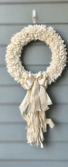 a white wreath hanging on the side of a house