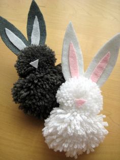 two black and white stuffed animals sitting on top of a wooden table next to each other