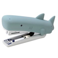 a stapler with a shark on top of it and a pen in the middle