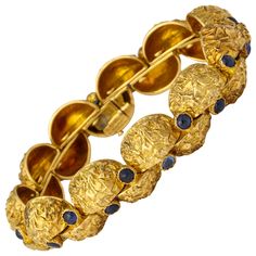 A modern and unusual 1970s bracelet from Cartier-Paris with deeply textured finish on quarter round segments of 18K gold each set with a cabochon sapphire and hinged to move independently and comfortably around the wrist. Measuring 7 1/2 inches long. Weighing 69.2 grams. Cartier mark and gold marks. High Jewelry Bracelet, Octopus Bracelet, Cartier Gold, Gold Link Bracelet, Antique Bracelets, Cartier Jewelry, Vintage Style Jewellery, Sapphire Bracelet, Antique Diamond